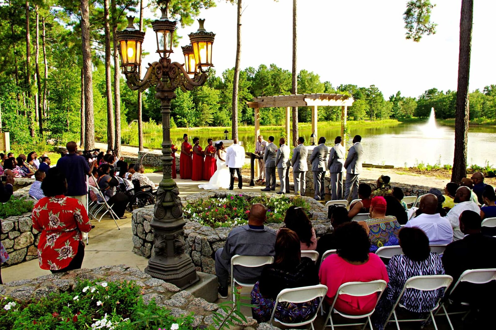 A wedding ceremony with many people sitting in chairs.