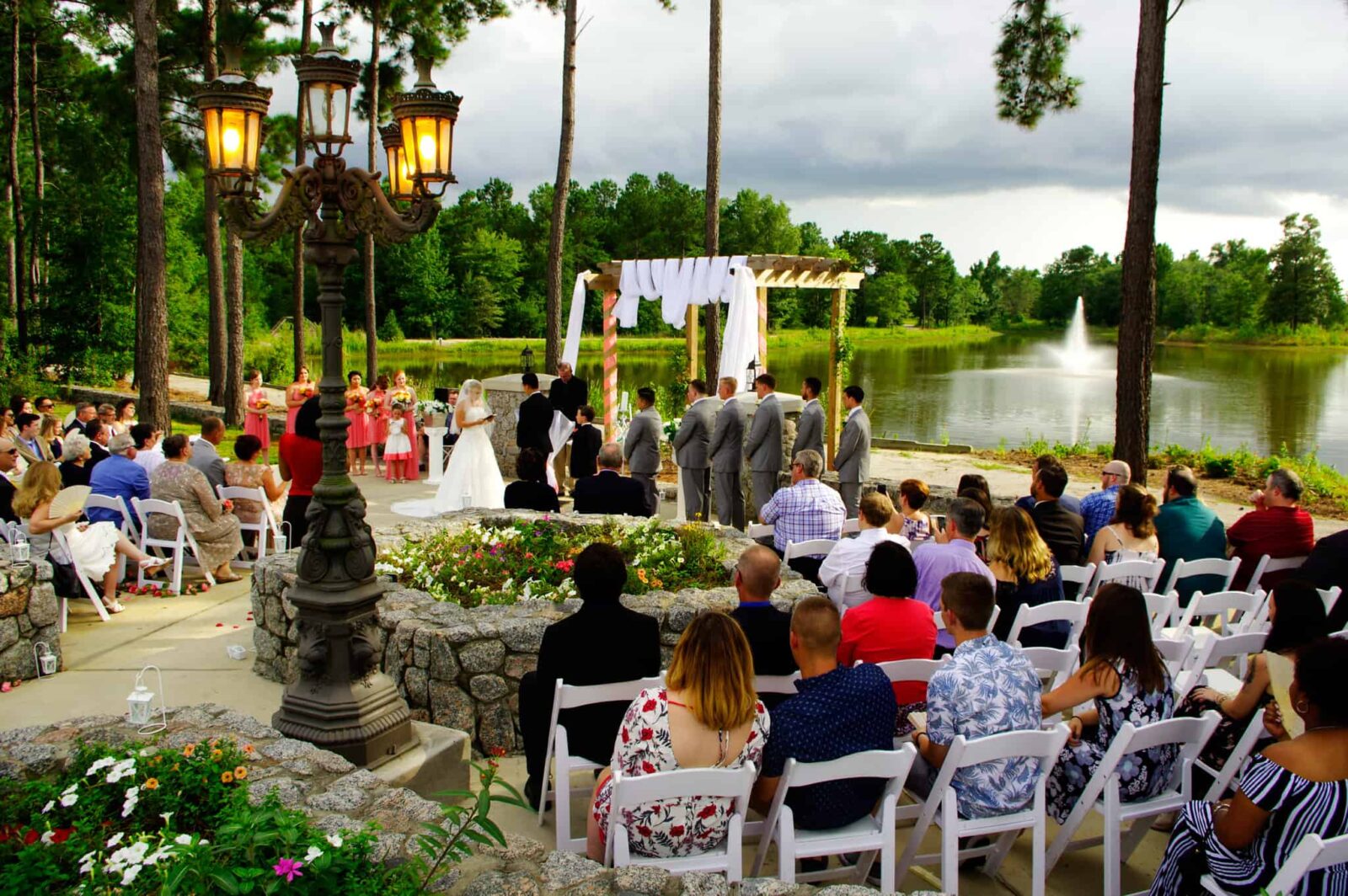 A group of people sitting in chairs at an outdoor wedding.