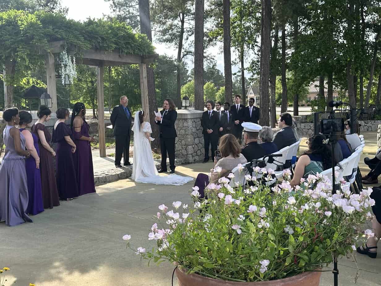 Couple exchanging vows under the arbor at Mariani's Venue near Florence, SC